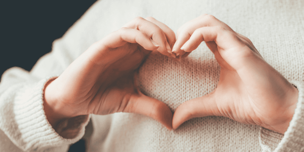 Image of hands making a heart showing the importance of self-love and self-confidence