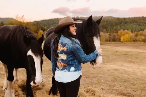Kelly with her horses in one of her custom jackets demonstrating how you can start a business at any age.